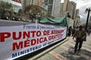 Un hombre camina en frente a un punto de atención donde profesionales del ministerio boliviano de Salud ofrecen atención ambulante gratuita a la población boliviana para contrarrestar la huelga indefinida de médicos que cumplió, este martes 3 de abril, una semana contra un decreto del presidente Evo Morales que aumenta su jornada laboral de seis a ocho horas. EFE