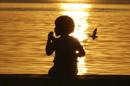 Un nIño observa una puesta de sol en Manila, Filipinas. EFE/Archivo