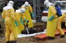 Varios especialistas de la salud transportan el cuerpo sin vida de una víctima del ébola en Paynesville, a las afueras de Monrovia (Liberia) hoy, martes 9 de septiembre del 2014. EFE