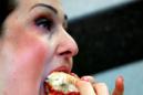 Una mujer come una hamburguesa en un restaurante de comida rápida en Londres. EFE/Archivo