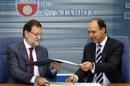 El presidente del Gobierno, Mariano Rajoy (i), y el presidente de Cantabria, Ignacio Diego, intercambian los documentos durante la firma del convenio. EFE