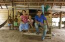 Esta imagen del lunes 11 de mayo de 2015 muestra a Joani Londoño, de 5 años, en el centro, sentada entre su padre Pío V Londoño, a la derecha, y su madre, Edith Díaz, en su vivienda de Crucito, en el estado colombiano de Córdoba. La madre de Joani djo que la niña nació prematura, con un pie deforme y sin una pierna después de que la mujer sufriera problemas en su embarazo luego de comer frutas de su huerto, fumigado con productos químicos desde un avión. "A los pocos 15 días se rompió el líquido amniótico y mi bebé nació prematuramente con sólo seis meses ", se lamenta Díaz. (AP Foto/Fernando Vergara)