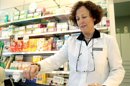 Una farmacéutica pasa la tarjeta sanitaria para realizar el copago. EFE/Archivo