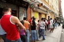 Inmigrantes irregulares hacen cola ante una oficina de la Seguridad Social en Madrid. EFE/Archivo