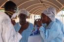 ARCHIVO - En esta foto de archivo del 25 de octubre de 2014, trabajadores de la salud se colocan equipo de seguridad antes de tratar a un enfermo de ébola en Kayes, Mali. El último paciente con ébola tratado en el país sobrevivió a la enfermedad y fue dado de alta, informó el Ministerio de Salud de Mali el viernes 12 de diciembre de 2014. (AP Foto/Baba Ahmed, File)