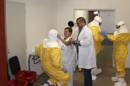 Fotografía facilitada por el Hospital La Paz-Carlos III de personal poniéndose el equipamiento especial (traje impermeable, pernera, fundas para el calzado, mascarilla de alta seguridad o doble guante) que se desecha al salir de la habitación, para atender al religioso y médico español Manuel García Viejo. EFE