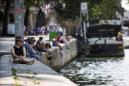 Varias personas descansan en la orilla del Sena, junto a Notre Dame en París, Francia durante la ola de calor que asola la capital francesa. EFE