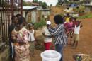 Una trabajadora del equipo médico comunitario "Save The Children" habla con habitantes en una jornada de sensibilización puerta a puerta sobre prevención frente al virus del ébola. EFE/Archivo