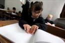 En la imagen, una estudiante ciega, de siete años, lee un libro en braille, EFE/Archivo