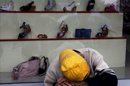 Un vagabundo duerme apoyado en el escaparate de una zapatería en el centro de Bucarest (Hungría). EFE/Archivo