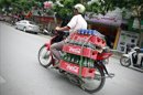 Un hombre transporta en su motocicleta cajas con botellas de Coca-Cola en una calle de Hanoi, Vietnam. EFE