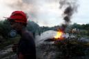 Fotografía tomada el pasado 3 de junio en la que se registró a un hombre al cruzar frente a un bloqueo de la vía Panamericana, entre Cali y Popayán, al suroccidente de Colombia, en medio del paro agrario que indígenas y campesinos adelantan hace ocho días. EFE/Archivo