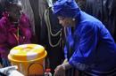 En esta foto del 26 de julio del 2014, la presidenta de Liberia Ellen Johnson Sirleaf, der., demuestra cómo lavarse las manos adecuadamente para prevenir la propagación del virus del ébola durante las celebraciones del Día de la Independencia en Monrovia, Liberia. La epidemia que afecta Liberia, Sierra Leona y Guinea es la mayor de la historia. (AP Foto/Abbas Dulleh)