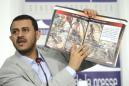 Hamza al-Houthim, jefe de la delegación Hutí, muestra fotografías de niños muertos y heridos mientras habla sobre derechos humanos durante una conferencia de prensa en el marco de las negociaciones de paz para Yemen, el jueves 18 de junio de 2015, en el Club de Prensa de Ginebra, en Suiza. (Foto de Martial Trezzini/Keystone vía AP)