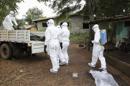 Varios enfermeros liberianos mientras rocían con desinfectante una casa tras retirar el cadáver de una de las víctimas del ébola en la comunidad de Virginia, a las afueras de Monrovia. EFE/Archivo