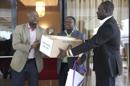 El viceministro de Sanidad para Servicios de Prevención liberiano, Tolbert Nyenswah (der), recibe una caja del tratamiento experimental contra el ébola Zmapp de manos del ministro liberiano de Asuntos Exteriores, Augustine Gaufan (izq), a su llegada al Aeropuerto Internacional Roberts en Margibi (Liberia) hoy, miércoles 13 de agosto de 2014. EFE
