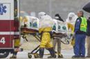 Trabajadores sanitarios con trajes de protección transportan al doctor Martin Salia, un cirujano que trabajaba en Sierra Leona diagnosticado de ébola, desde un jet que le llevó de Sierra Leona a una ambulancia que le llevaría al Centro Médico de Nebraska en Omaha, Nebraska, Estados Unidos. El doctor Salia es el tercer paciente de ébola que atiende el hospital y el décimo atendido en Estados Unidos. (AP Foto/Nati Harnik)