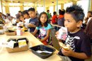 Varios estudiantes toman sus alimentos en un comedor de escuela primaria. EFE/Archivo