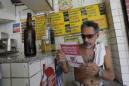 Un hombre lee un panfleto con información sobre cómo erradicar el mosquito Aedes aegypti que propaga el virus del zika en un bar en Rio de Janeiro, Brasil, el sábado 13 de febrero de 2016. Más de 200.000 soldados del ejército, la marina y fuerzas aéreas se dispersan a lo largo de Brasil para demostrarle a la gente cómo eliminar el mosquito. (Foto AP/Silvia Izquierdo)
