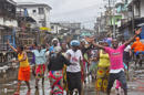 La gente celebra en las calles de West Point que las autoridades hayan puesto fin al bloqueo de una semana de ese vecinario en Liberia el 30 de agosto del 2014. La cuarentena tuvo por objeto contener la propagación del brote de ébola. (AP Foto/Abbas Dulleh)