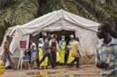 En fotografía del sábado 9 de agosto de 2014 se ve a trabajadores sanitarios haciendo análisis para descartar contagios de ébola antes de entrar al hospital gubernamental Kenema en Sierra Leona. (Foto de AP/Michael Duff)