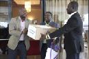 El viceministro de Sanidad para Servicios de Prevención liberiano, Tolbert Nyenswah (der), recibe una caja del tratamiento experimental contra el ébola Zmapp de manos del ministro liberiano de Asuntos Exteriores, Augustine Gaufan (izq), a su llegada al Aeropuerto Internacional Roberts en Margibi (Liberia) hoy, miércoles 13 de agosto de 2014. EFE