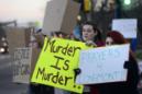 Personas sostienen letreros durante una protesta contra Dynel Lane en Longmont, Colorado, el jueves 19 de marzo de 2015. Lane está acusada de acuchillar en su casa a una mujer embarazada en el estómago y retirarle el feto. Lane está detenida. La mujer embarazada sobrevivió a la agresión pero no la bebé que llevaba en el vientre. (AP Foto/The Daily Camera, Jeremy Papasso)