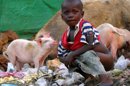 Un niño defecando entre montones de basura en un poblado de chabolas de Freetown, la capital de Sierra Leona, donde miles de personas viven en precarias condiciones después de una década de terrible guerra civil. EFE/Archivo