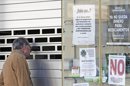 Un hombre observa el interior de una farmacia cerrada en seguimiento de la huelga indefinida de la Comunidad Valenciana. EFE/Archivo