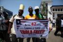 Ciudadanos iberianos sostienen carteles con mensajes de "Liberia libre del ébola" durante una celebración. EFE/Archivo
