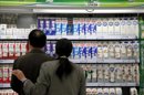 Una pareja mira envases de cartón de leche fresca en un supermercado de Shanghai, China. EFE/Archivo