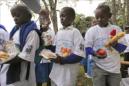 Niños keniatas reciben comida de un grupo de voluntarios durante un evento organizado por el Programa de Alimentación Mundial en Nairobi, Kenia. EFE/Archivo