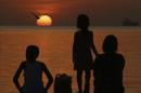 Unos niños observan una puesta de sol. EFE/Archivo