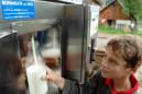 Un niño llena una botella con leche fresca. EFE/Archivo