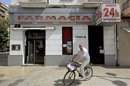 Un hombre pasa este mediodía ante una farmacia abierta 24 horas. EFE/Archivo