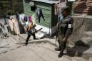 En esta imagen del 5 de febrero de 2016, un soldado proporciona seguridad a un trabajador del Ministerio de Salud que fumiga contra el mosquito Aedes aegypti en La Comuna 2, un vecindario de Ciudad de Guatemala. Para los trabajadores de la salud que combaten el zika en buena parte de América Central, la amenaza más inmediata no es el mosquito que transmite el virus. Son las pandillas que controlan barrios y calles y a veces amenazan sus vidas. (AP Foto/Moises Castillo)