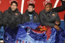 Los jugadores del FC Barcleona, Cesc Fábregas, Leo Messi y Eric Abidal (i-d), se protejen con una manta en el banquillo antes del partido de Copa del Rey en Pamplona. EFE/Archivo
