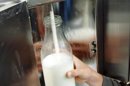 Una persona rellena una botella de leche. EFE/Archivo