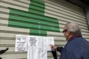 Un usuario consulta en una farmacia cerrada la lista de los servicios mínimos, la semana pasada en Valencia. EFE