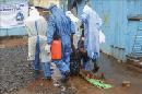 Enfermeros liberianos llevan a una paciente sospechosa de tener el virus del Ébola, en el centro de tratamiento para el Ébola John F. Kennedy en Monrovia (Liberia). EFE/Archivo