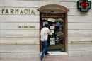 Un cliente entrando el pasado mes de diciembre en una farmacia abierta por servicios mínimos durante una jornada de cierre ese mes en la Comunidad Valenciana en protesta por el incumplimiento del plan de pagos. EFE