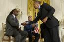 El presidente estadounidense Barack Obama (d) saluda al exjugador de la NFL LaVar Arrington (i) junto al exjugador de fútbol player Taylor Twellman (c) durante un acto para concienciar sobre la incidencia de la conmoción cerebral celebrado en el Ala Oeste de la Casa Blanca, Washington, Estados Unidos hoy 29 de mayo de 2014. EFE