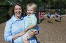 Christy Wolford, una sobreviviente de cáncer de mama, con su hijo menor Lucas, de 2 años, mientras sus hijos Lauren, de 8 años, Alexander, de 4, y Everett, de 3, juegan en unos columpios en la escuela que dirige Wolford en Fort Collins, Colorado en una fotografía del 29 de mayo de 2014. Los médicos podrían haber encontrado una manera de ayudar a las jóvenes con cáncer de mama a evitar la infertilidad causada por la quimioterapia. Al parecer sólo basta con una inyección de medicamentos en los ovarios para aumentar las posibilidades de que sigan sanos después de que termine su tratamiento e incluso podría aumentar sus posibilidades de supervivencia, según un estudio del que formó parte Wolford. (Foto AP/Ed Andrieski)