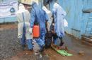 Enfermeros liberianos cargan a una paciente sospechosa de poseer el virus del Ébola, en el centro de tratamiento para el Ébola John F. Kennedy en Monrovia (Liberia) ayer. EFE