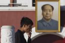 Un hombre fuma junto a un retrato del fallecido líder chino Mao Zedong colgado en una réplica de la puerta de Tiananmen en Yinchuan, en la región noroccidental de Ningxia Hui, el jueves 8 de octubre de 2015. (AP Foto/Ng Han Guan)