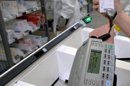 Una mujer escanea con un aparato portátil el código de barras de un medicamento mientras realiza el pedido de fármacos. EFE/Archivo