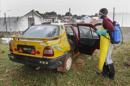 Un sanitario de liberia desinfecta un taxi utilizado para el transporte de enfermos de ébola en Monrovia (Liberia). EFE