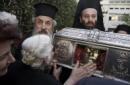 Griegos ortodoxos besan las reliquias de Santa Bárbara a las puertas del hospital público de Sabas el Santificado en Atenas (Grecia). EFE