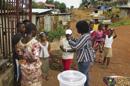 Una trabajadora del equipo médico comunitario "Save The Children" habla con habitantes en una jornada de sensibilización puerta a puerta sobre prevención frente al virus del ébola. EFE/Archivo