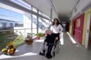 Una anciana en silla de rueda es ayudada por la gerente en una residencia para personas mayores. EFE/Archivo
